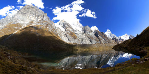 Panorama of snowy mountains and glacial lake valley in remote cordillera huayhuash in peru.