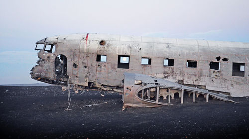 Abandoned airplane on runway against sky