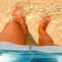 Low section of woman relaxing in swimming pool