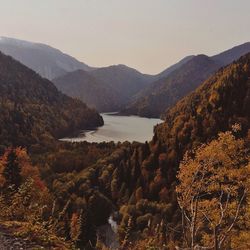 Scenic view of river by mountains against sky