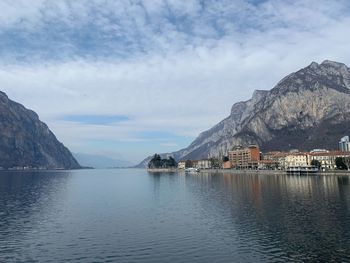 Scenic view of sea by mountains against sky