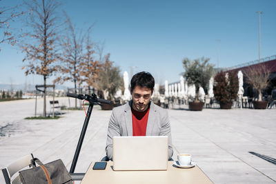 Portrait of young man sitting on table