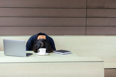 Low section of woman sitting on table