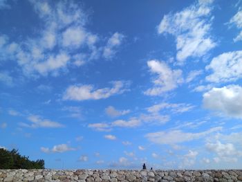 Low angle view of landscape against blue sky