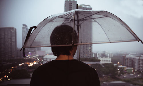 Rear view of man against buildings in city