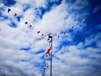 Low angle view of flags hanging against sky