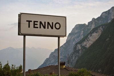 Road sign by mountains against sky