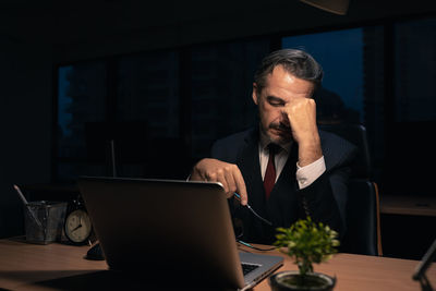 Man using mobile phone while sitting on table