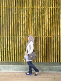 Full length of woman standing by railing