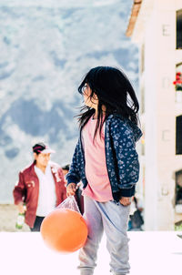 Girl standing on road during sunny day