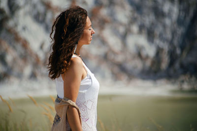 Young woman standing against trees