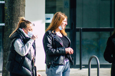 Side view of two women standing outdoors