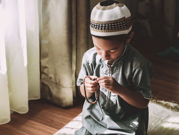 Cute boy wearing hat at home