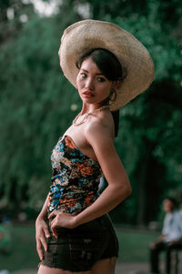 Portrait of a beautiful young woman standing against blurred background