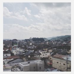 Cityscape against cloudy sky