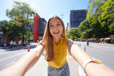 Beautiful smiling girl takes self portrait on paulista avenue, sao paulo, brazil.