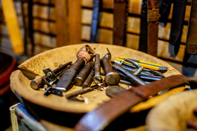 Close-up of rusty work tools on table at workshop