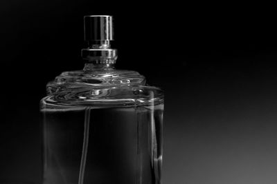 Close-up of glass bottle against black background