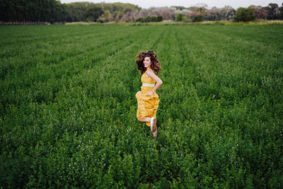 Rear view of woman running amidst plants