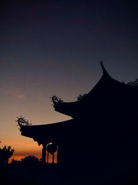 Low angle view of silhouette temple against sky during sunset