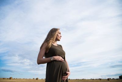 Side view of woman standing against sky