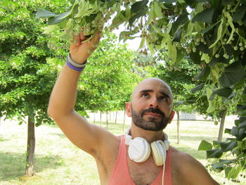 Portrait of man smiling against trees