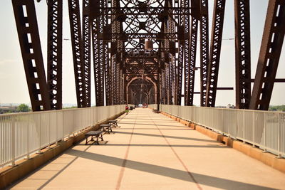 Footbridge in city against sky