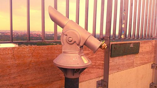 Side view of day telescope against railing