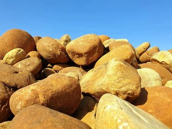 Close-up of rocks on rock against clear blue sky