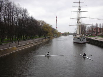 Sailboats in river against sky