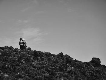 Men standing on cliff against sky