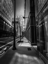 Empty road amidst buildings in city