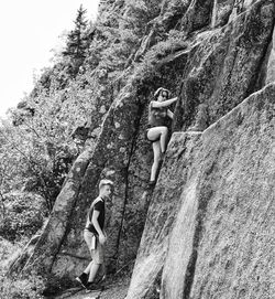 Low angle view of people on rock