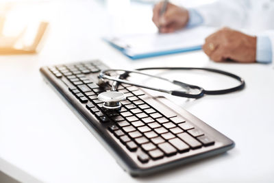 Close-up of stethoscope with calculator on table