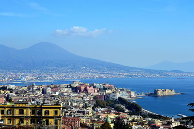 High angle view of town by sea against sky