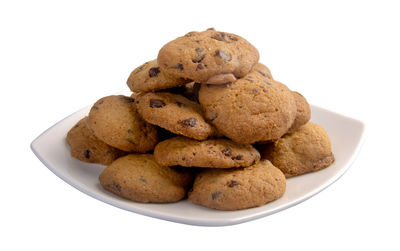 Close-up of cookies in plate against white background