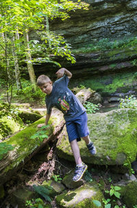 Full length of man on rock in forest