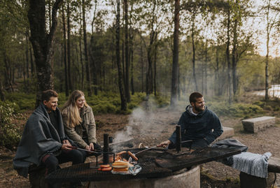 Friends having grill in forest