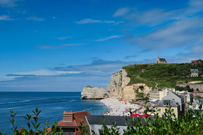 Scenic view of sea by buildings against sky