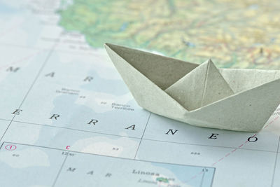 Close-up of paper boat on world map