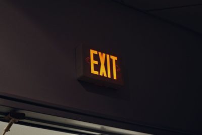 Low angle view of illuminated sign on wall at night