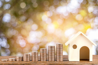 Close-up of coins with model home on table