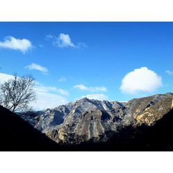 Scenic view of mountains against blue sky