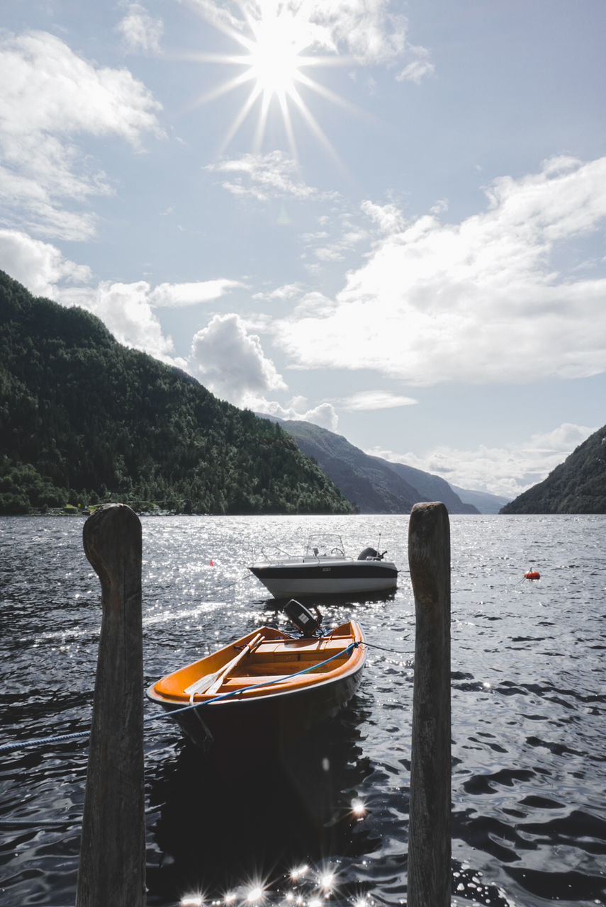 BOAT IN LAKE AGAINST MOUNTAINS