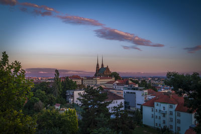 Buildings in city against sky during sunset