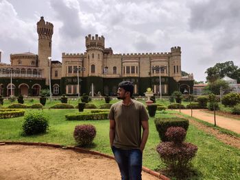 Man standing against historic building