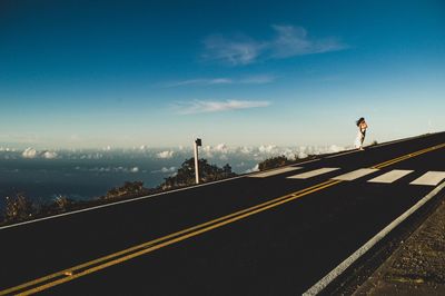 Man standing on road against sky