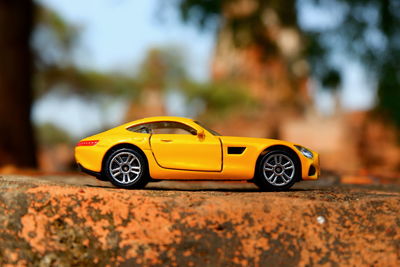 Close-up of yellow toy car on road