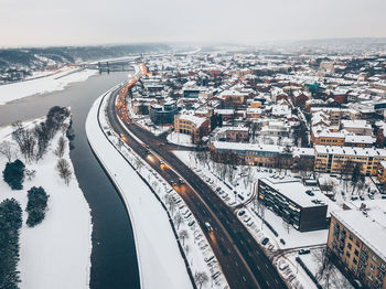 High angle view of river amidst cityscape during winter