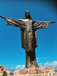 Low angle view of statue against blue sky